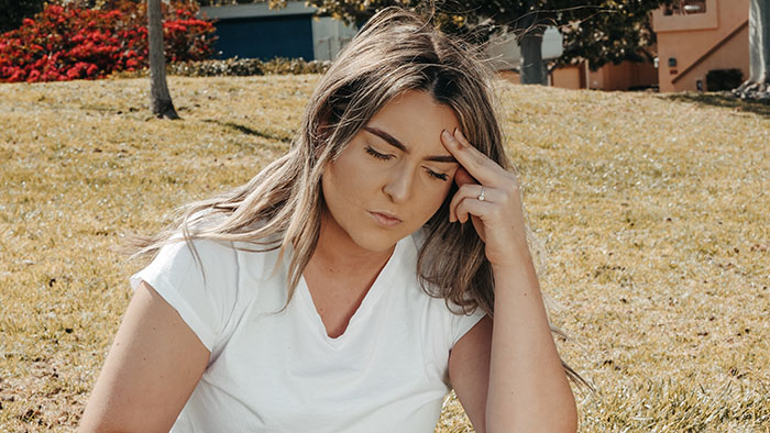 woman with a headache touching her temple