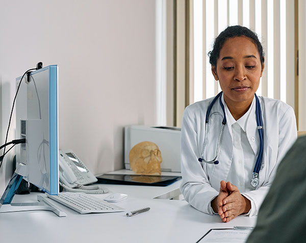 female doctor sitting at desk with patient