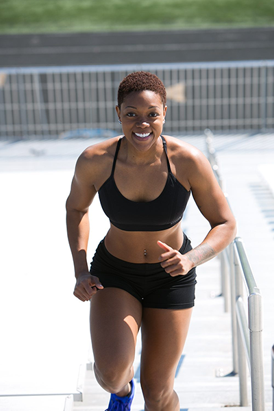 African American woman running up flight of stairs