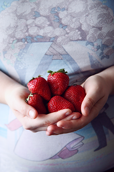 woman holding a bunch of strawberries