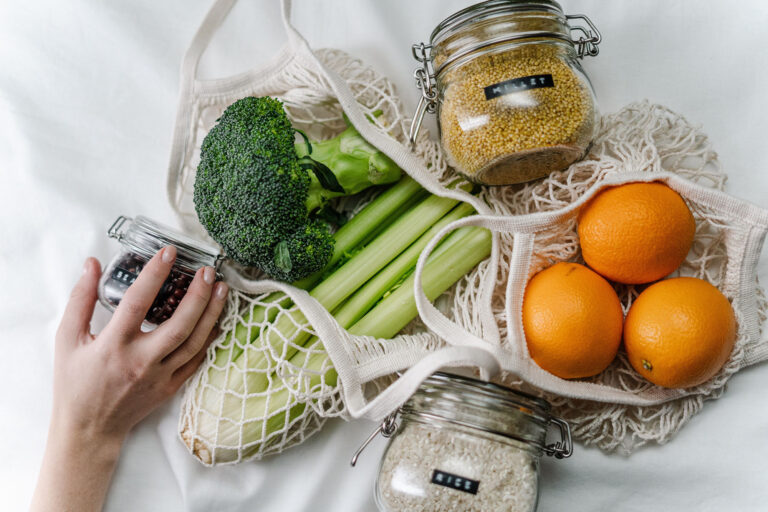 grocery bags with broccoli, oranges, rice and celery